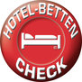Logo des Hotel-Betten-Check, rotes rundes Icon mit weißer umlaufender Schrift und mitig einem weißen Bett